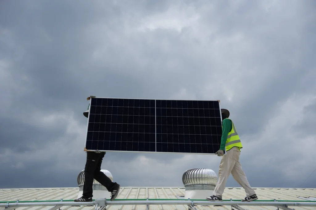 ภาพช่างติดตั้ง Solar Cell จาก Solar wing กำลังยกแผงโซลาร์สำหรับติดตั้งโรงงาน 